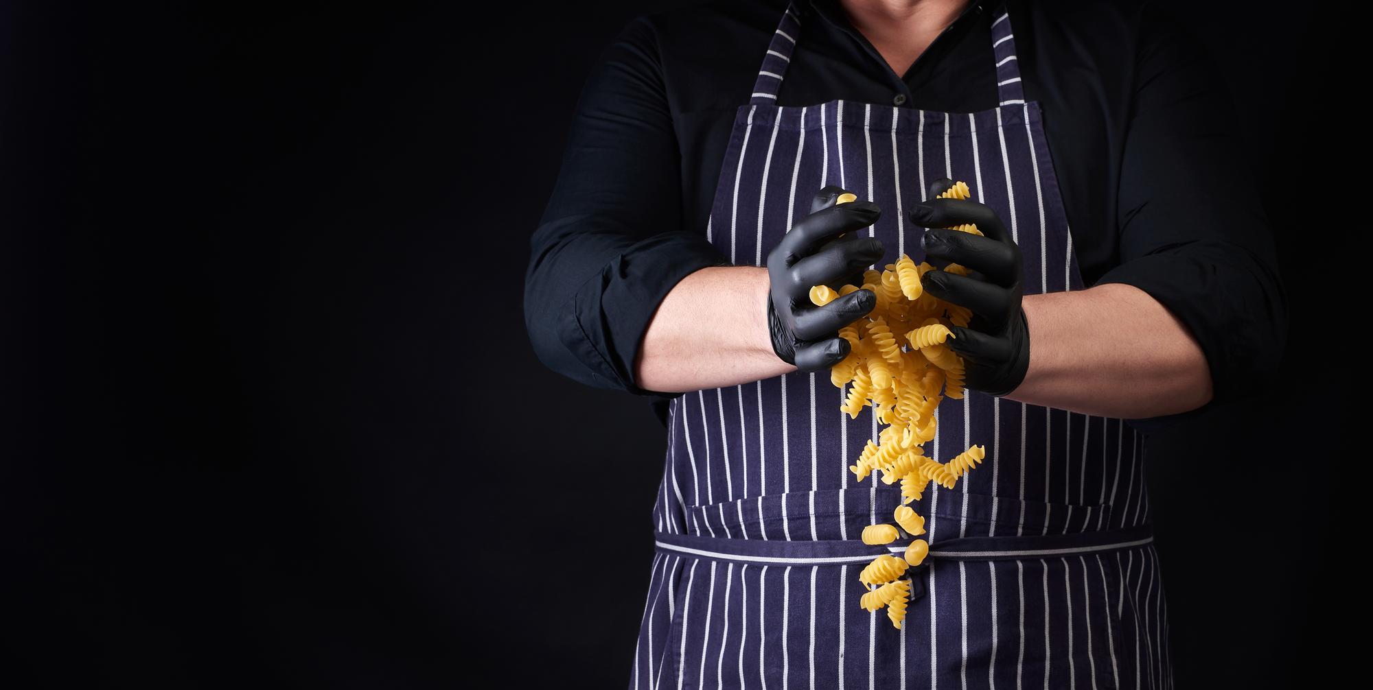 Chef che impasta pasta fresca in cucina calda